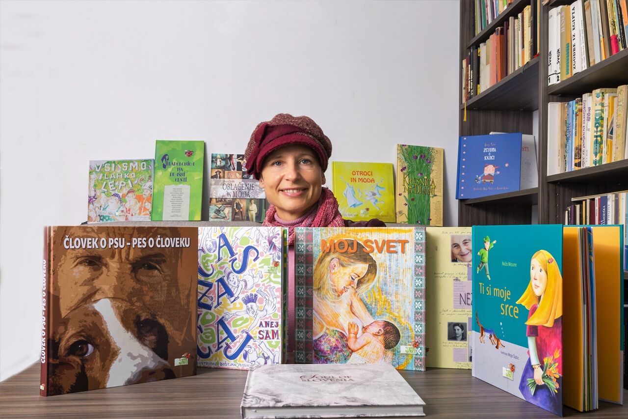 The president of the Jasa Society mag. Mateja Jamnik with the Onežimo svet book series.